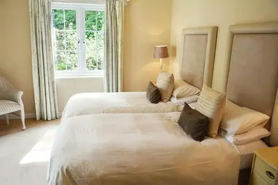 a hotel room with two beds and a window at St Corantyn Cottage in Helston