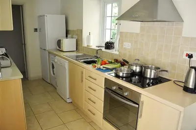 a kitchen with a sink and a stove top oven at St Corantyn Cottage in Helston