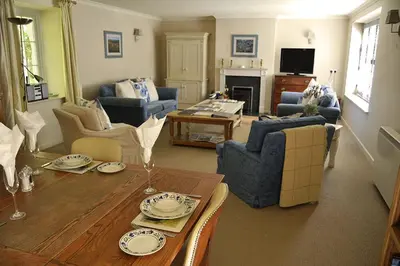 a living room with a table and couches at St Corantyn Cottage in Helston