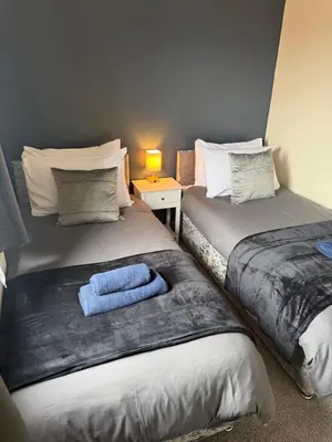 two beds sitting next to each other in a room at Eton Court Apartments in Newquay