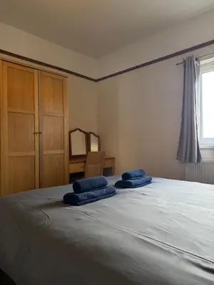 a bedroom with a bed with blue pillows on it at Eton Court Apartments in Newquay