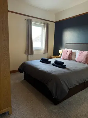 a bedroom with a bed with two towels on it at Eton Court Apartments in Newquay