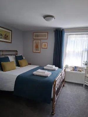 a bedroom with a large bed with towels on it at Ivy Cottage, in Lostwithiel
