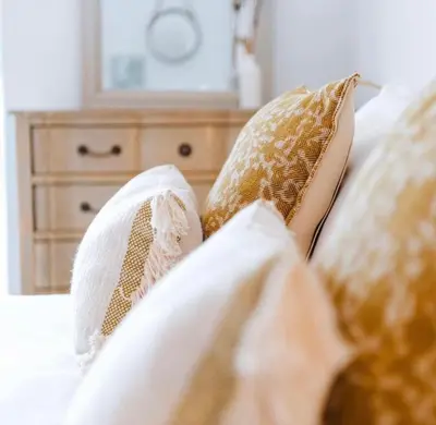 a bed with pillows and a dresser in a bedroom at Primrose House St. Ives in St Ives