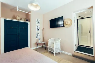 a bedroom with a blue door and a chair at Primrose House St. Ives in St Ives