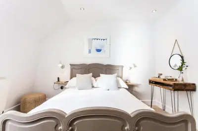 a bedroom with a large bed with white sheets at Primrose House St. Ives in St Ives