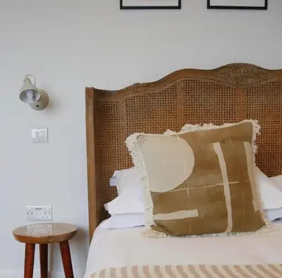 a bed with a wooden headboard with a pillow on it at Primrose House St. Ives in St Ives