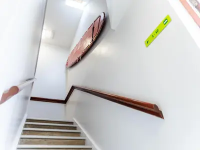 a staircase in a building with a sign on the wall at YHA Treyarnon Bay in Padstow