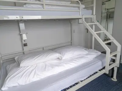 a white bunk bed in a room with a ladder at YHA Treyarnon Bay in Padstow