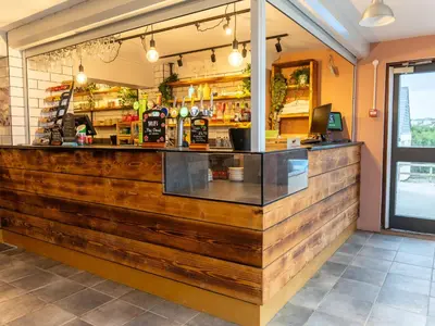 a bar in a restaurant with a wooden counter at YHA Treyarnon Bay in Padstow
