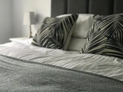 a bed with black and white pillows on it at Olcote House in Padstow