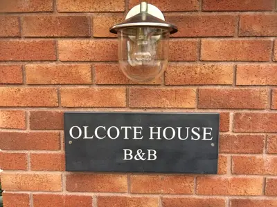 a street sign on a brick wall with a light at Olcote House in Padstow
