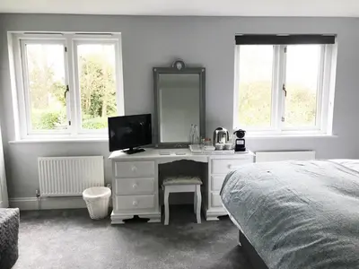 a bedroom with a desk with a mirror and a bed at Olcote House in Padstow