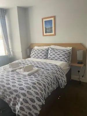 a bedroom with a bed with a blue and white comforter at The Trelinda Guest House in Newquay