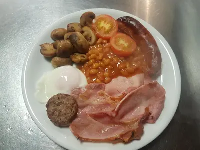 a plate of food with eggs sausage beans and potatoes at The Trelinda Guest House in Newquay