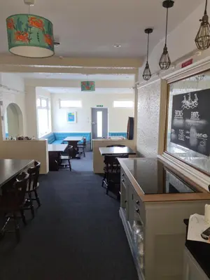 a dining room with tables and chairs and a bar at The Trelinda Guest House in Newquay