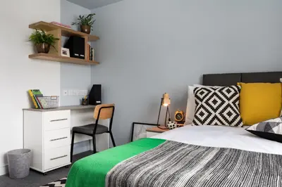 a bedroom with a bed with a desk and a chair at Roseland House in Falmouth