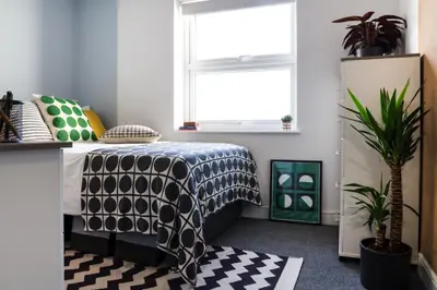 a bedroom with a bed with a black and white comforter at Roseland House in Falmouth