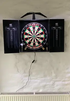 a dartboard is hanging on a wall at Polean Farm Old Farmhouse - With Large Jacuzzi, Games Room, Near the Sea and with Free Access to a Nearby Pool in Looe