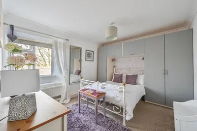 a bedroom with a white bed and a table at Polean Farm Old Farmhouse - With Large Jacuzzi, Games Room, Near the Sea and with Free Access to a Nearby Pool in Looe
