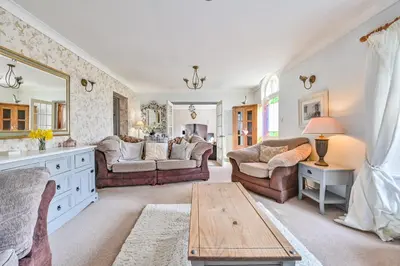 a living room with two couches and a table at Polean Farm Old Farmhouse - With Large Jacuzzi, Games Room, Near the Sea and with Free Access to a Nearby Pool in Looe