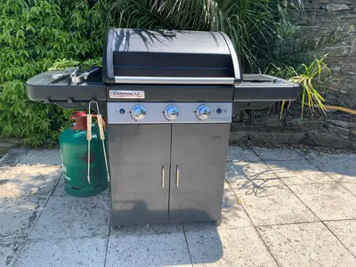 a grill sitting on a sidewalk next to a fire hydrant at Polean Farm Old Farmhouse - With Large Jacuzzi, Games Room, Near the Sea and with Free Access to a Nearby Pool in Looe