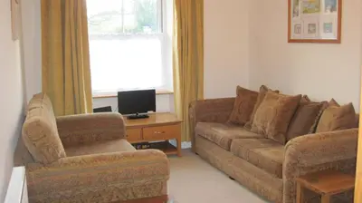 a living room with a couch and a chair at Glengarth in Penryn