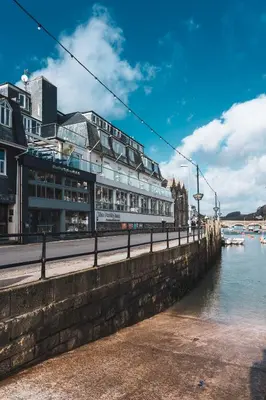 a building next to a body of water at Portbyhan Hotel in Looe