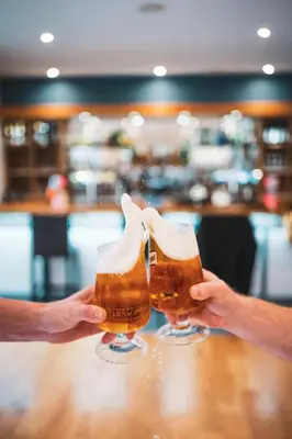 two people holding up glasses of beer at Portbyhan Hotel in Looe