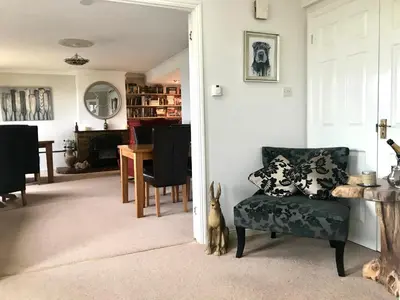 a living room with a couch and a dining room at Wellingtons in Fowey