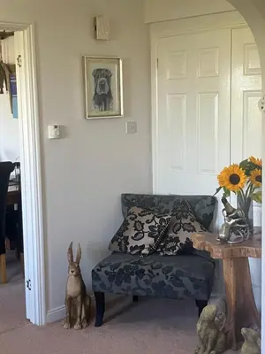 a room with a couch and a table with a vase at Wellingtons in Fowey