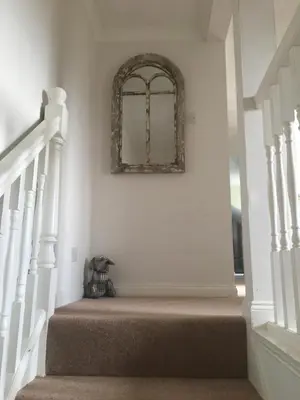 a stairway with a mirror on the wall at Wellingtons in Fowey
