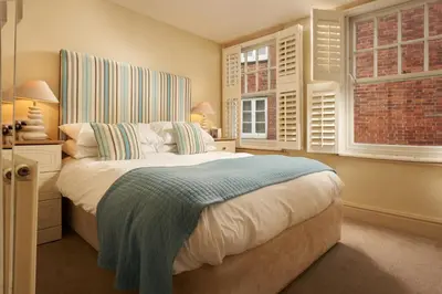 a bedroom with a bed and two windows at The Old Custom House in Padstow