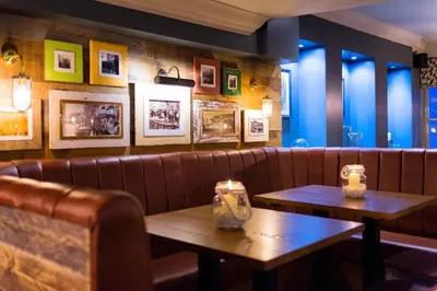 a restaurant with two tables in front of a couch at The Old Custom House in Padstow
