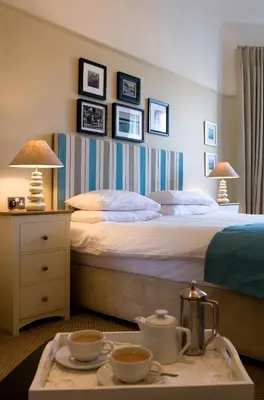 a hotel room with a bed and a tray with tea sets at The Old Custom House in Padstow