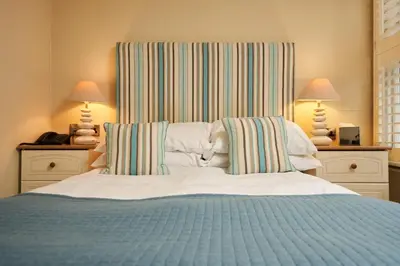 a bedroom with a large bed with two lamps at The Old Custom House in Padstow