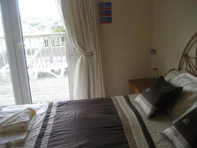 a bedroom with a bed next to a sliding glass door at Priory Lodge Hotel in Newquay