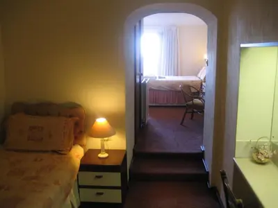 a room with a bed and a hallway with a bedroom at Priory Lodge Hotel in Newquay