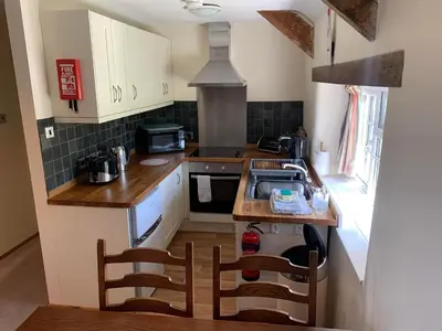 a small kitchen with a sink and a stove at The Hayloft in Bude