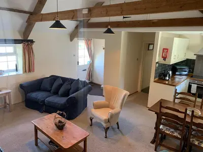 a living room with a blue couch and a table at The Hayloft in Bude