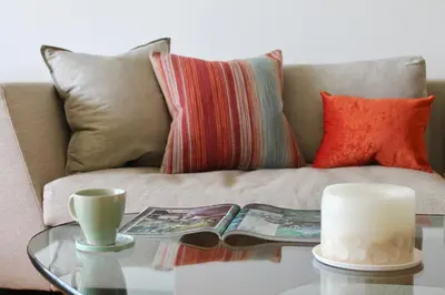 a living room with a couch with a glass table at Endcliffe in Falmouth