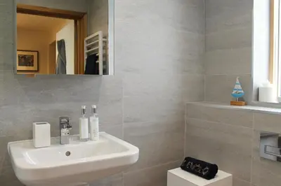 a bathroom with a white sink and a mirror at Endcliffe in Falmouth