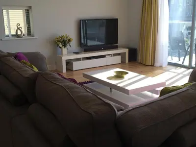 a living room with a couch and a tv at 9 Sandpiper Cottages in Newquay