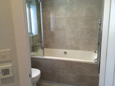 a bathroom with a tub and a toilet at 9 Sandpiper Cottages in Newquay