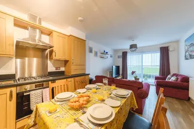 a kitchen with a table with food on it at Panoramic Sea-View Family Appartment , Free Parking, Sleeps 6 , Walk to Beach, Station, & Town in Newquay