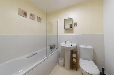 a white bathroom with a toilet and a sink at Panoramic Sea-View Family Appartment , Free Parking, Sleeps 6 , Walk to Beach, Station, & Town in Newquay
