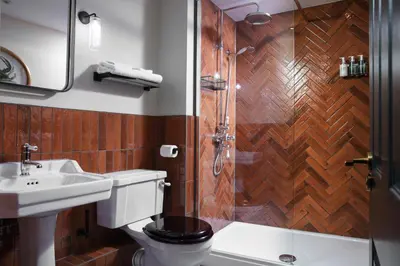 a bathroom with a toilet and a shower and a sink at The Wellington Hotel in Boscastle