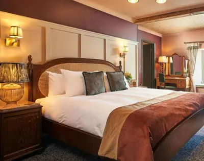 a bedroom with a large bed with a wooden headboard at The Wellington Hotel in Boscastle
