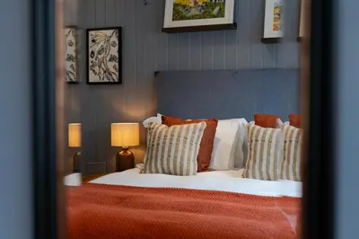 a bedroom with a white bed with pillows at Port Gaverne Hotel in Port Isaac