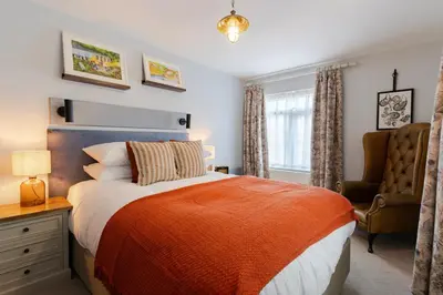a bedroom with a bed and a desk and a chair at Port Gaverne Hotel in Port Isaac